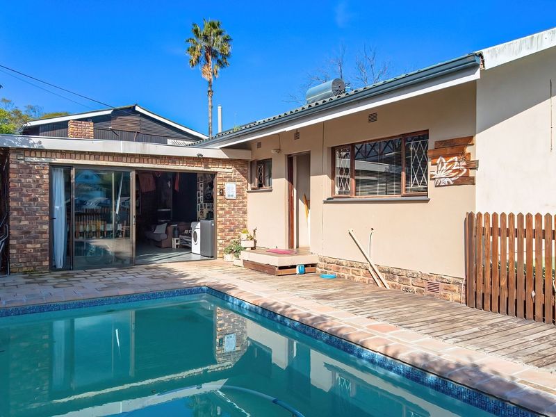 Outdoor pool area featuring a swimming pool, wooden decking, and direct access to the home via sliding glass doors.