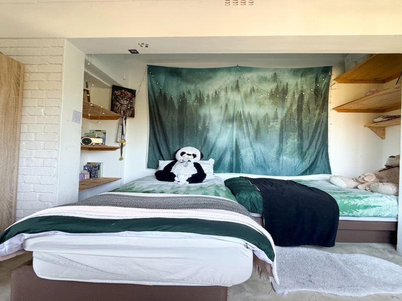 A bedroom featuring built-in cupboards and recessed shelving within a painted brick wall alcove.