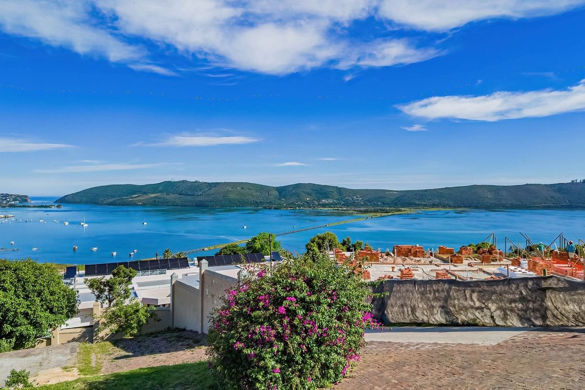 Elevated panoramic view overlooking the lagoon and surrounding landscape, featuring nearby residential construction and established greenery.
