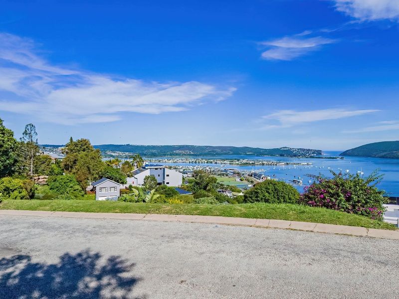 A scenic elevated view overlooking the estuary, surrounding hills, and coastal landscape, showcasing the prime location of the vacant residential land.