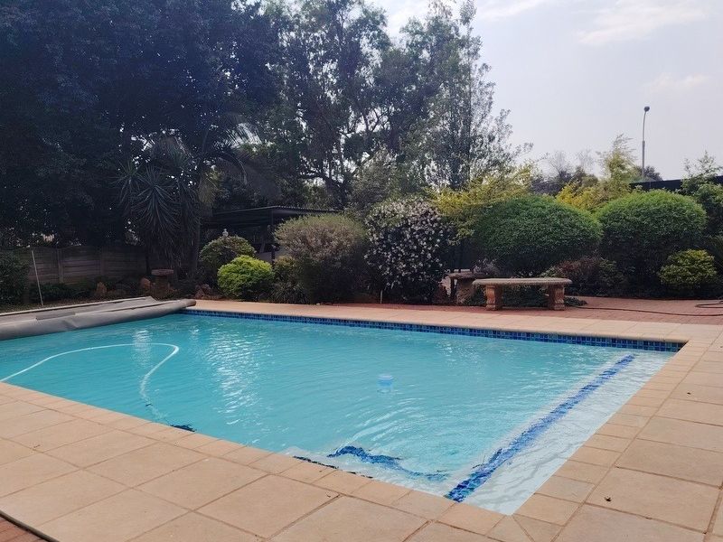 A well-maintained swimming pool area featuring a tiled surround and established garden landscaping, providing a private outdoor space.
