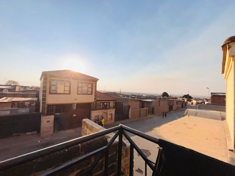 An elevated view overlooking the surrounding neighbourhood and street, captured from a balcony with a metal railing.