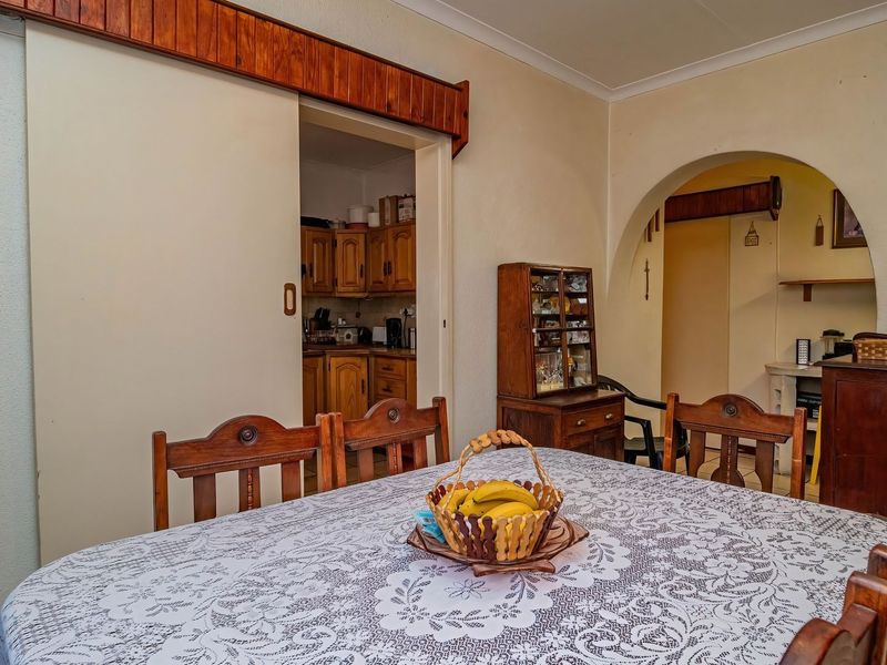 Dining room featuring a classic archway leading to an adjacent space and a sliding door providing access to the kitchen area.