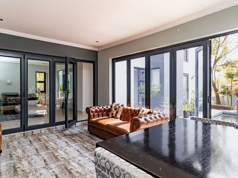 Spacious living area featuring large aluminium stacker doors that provide seamless indoor-outdoor flow to the patio and pool area.