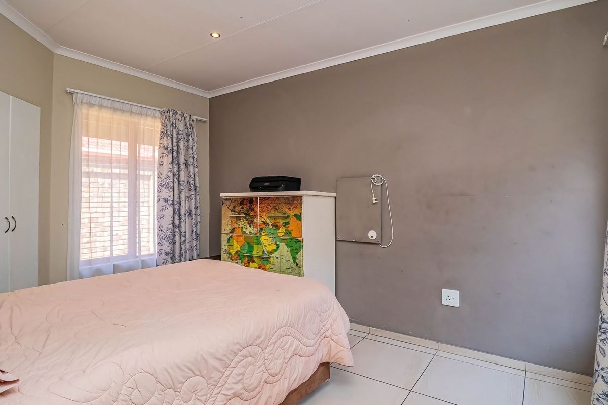 A bedroom featuring tiled flooring, built-in cupboard storage, and recessed ceiling lighting, with neutral wall tones ready for a fresh update.