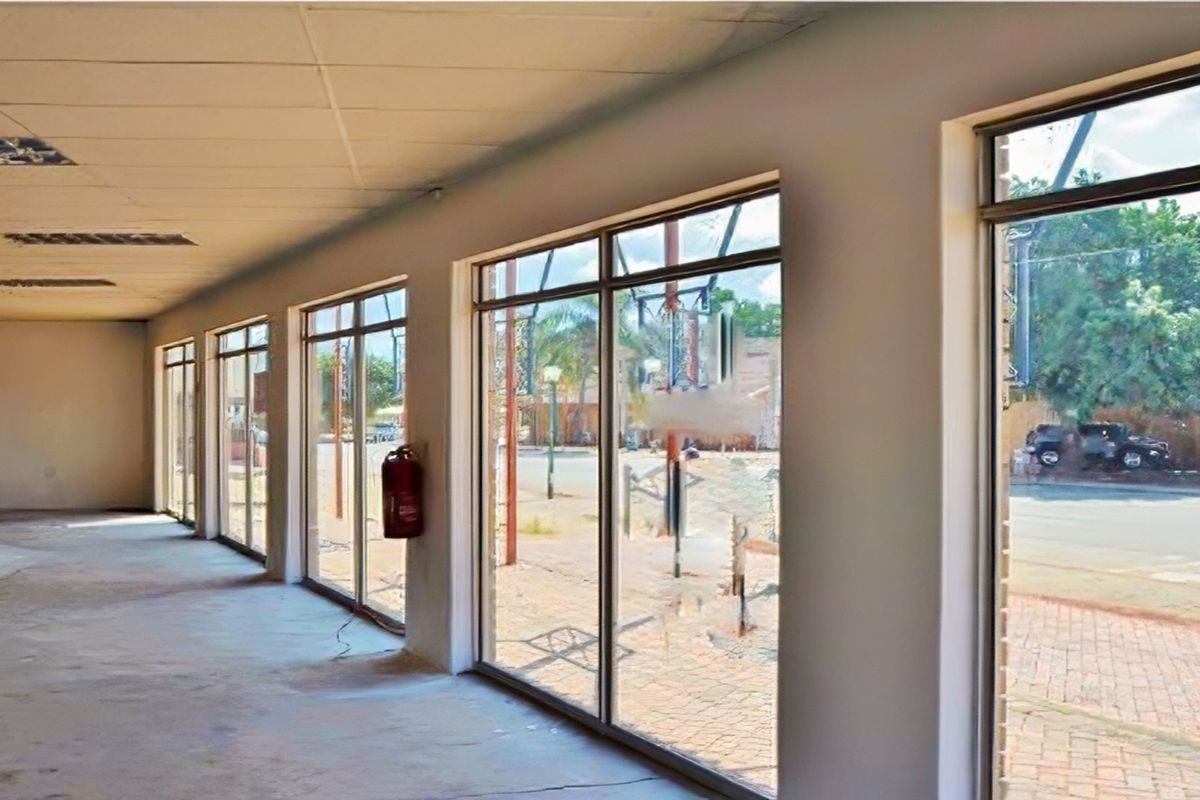 Spacious open-plan retail area featuring large display windows, suspended ceilings with recessed lighting, and a neutral interior ready for custom fit-out.