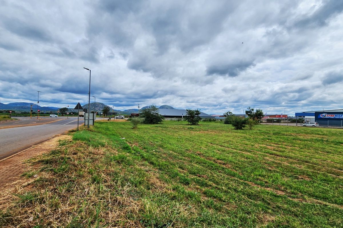 A view of the vacant commercial land parcel situated adjacent to a public road with established street lighting and surrounding commercial infrastructure.