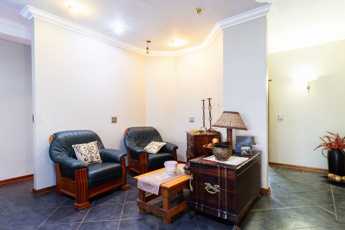 A cozy living area featuring dark slate tile flooring, recessed ceiling lighting, and decorative crown molding.