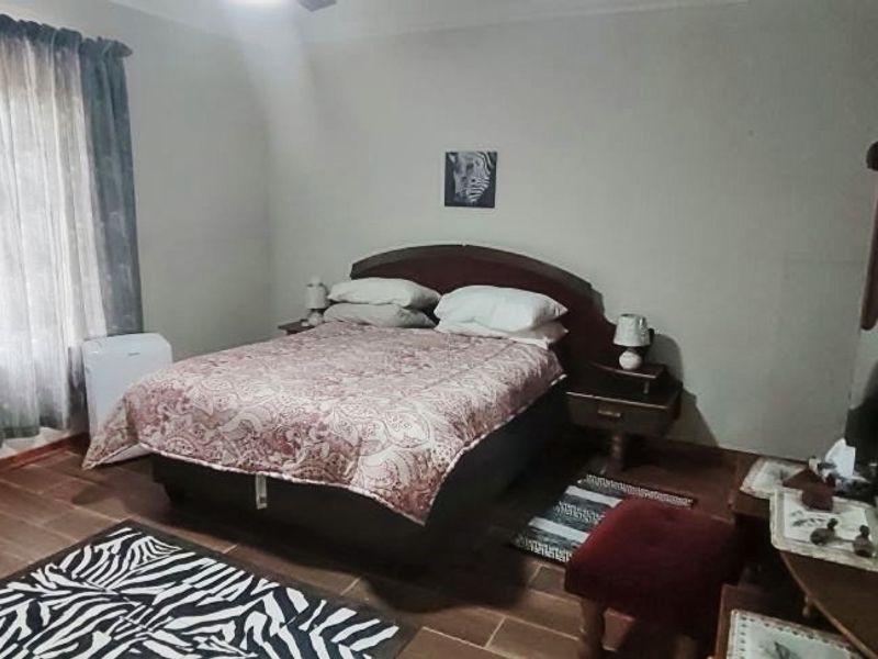 A standard bedroom featuring tiled flooring and window treatments, offering a functional space ready for personal updates and modern styling.