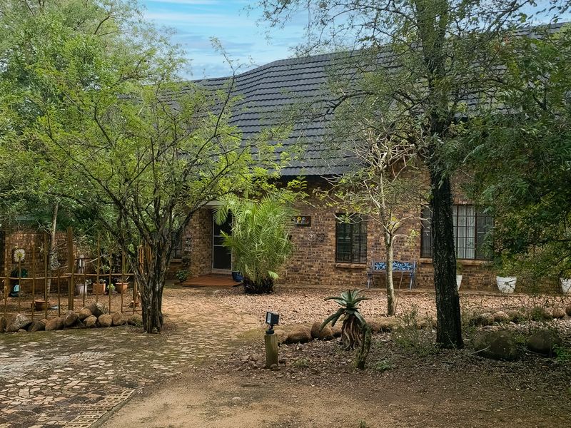 A charming face-brick house exterior featuring a tiled roof, paved driveway, and established garden surroundings, presenting a classic and well-maintained facade.