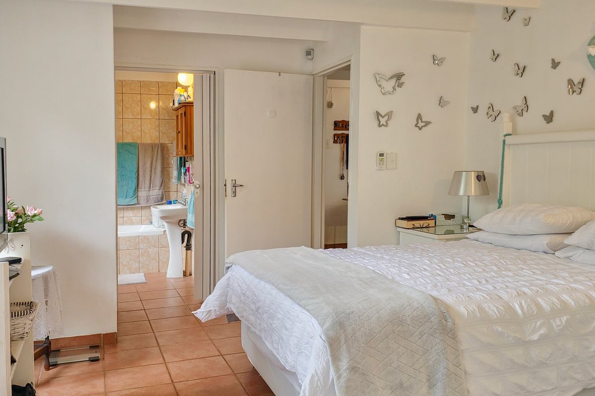 A bedroom featuring tiled flooring and direct access to an en-suite bathroom with a bathtub.