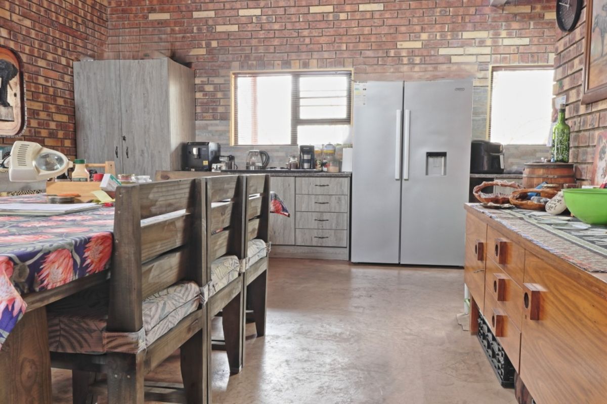 A rustic kitchen featuring exposed brick walls, concrete flooring, and built-in cabinetry, offering a functional space with a distinct industrial aesthetic.
