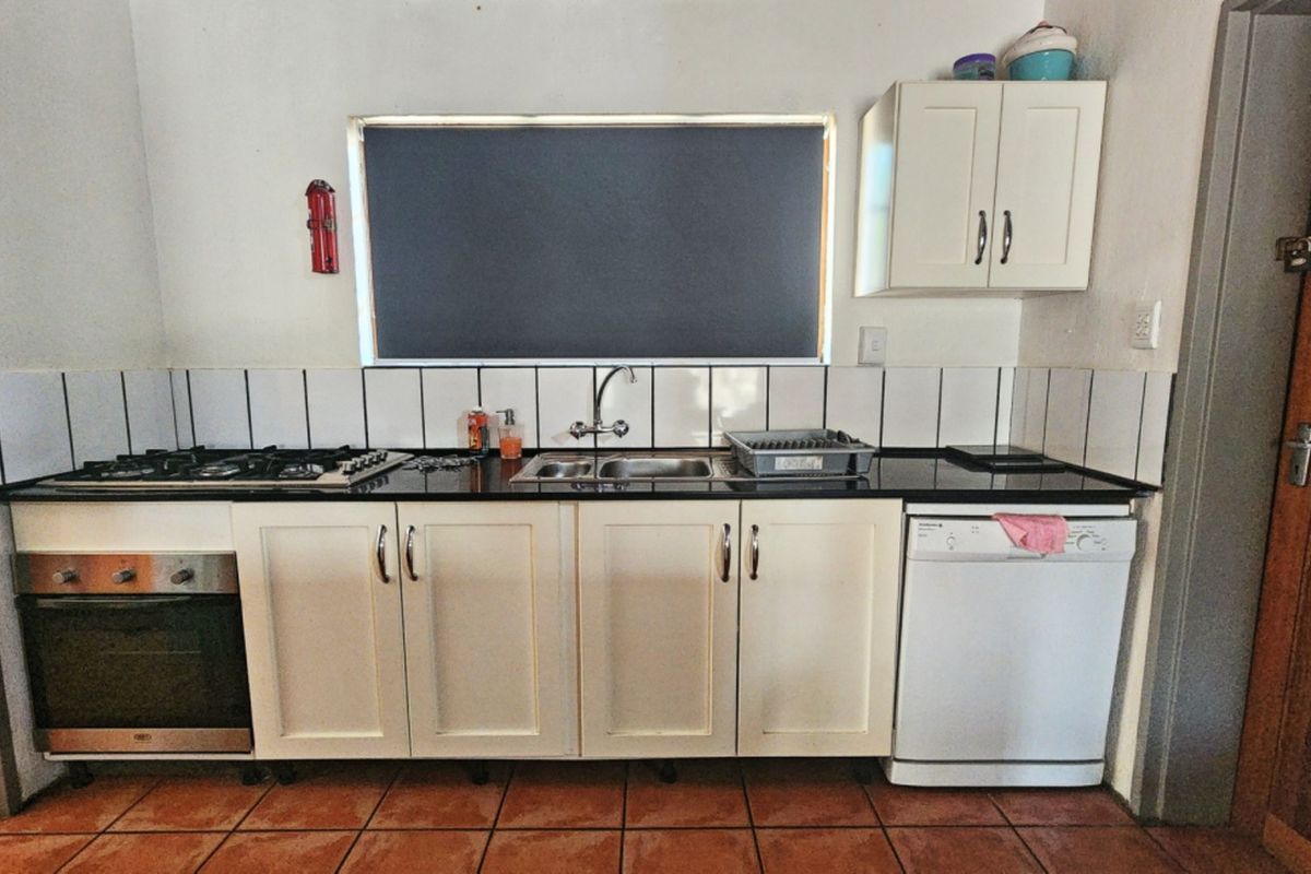 A functional kitchen featuring built-in cabinetry, a gas hob, an integrated oven, a double sink, and tiled flooring with a tiled backsplash.