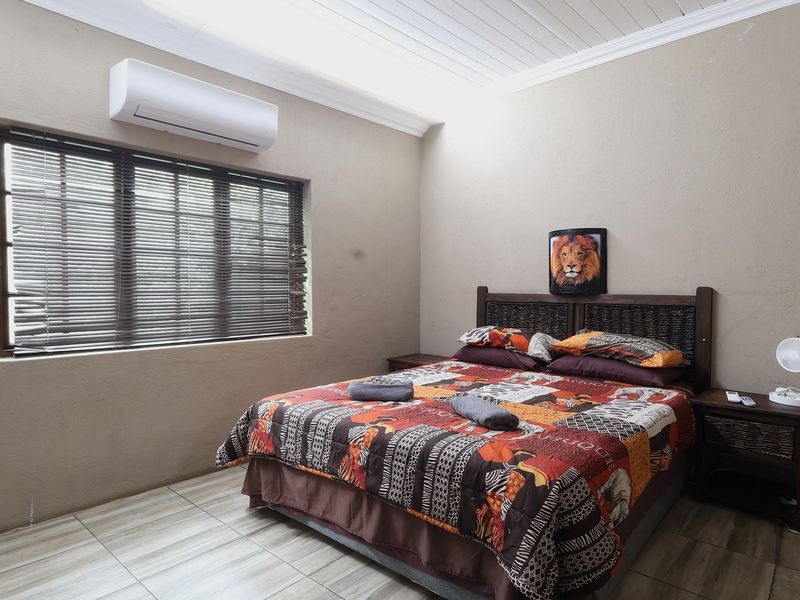 A bedroom featuring tiled flooring, a split-system air conditioner, and venetian blinds, with a tongue and groove ceiling finish.
