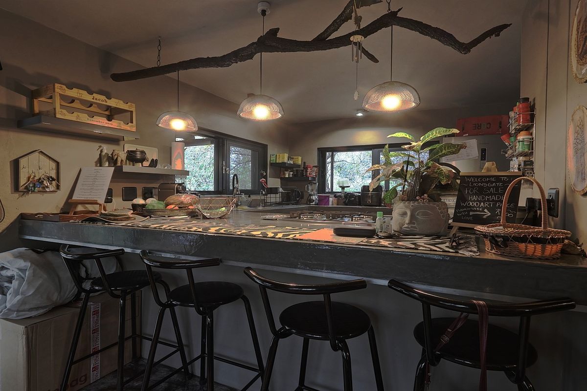 A kitchen featuring a prominent concrete breakfast bar, pendant lighting, and functional workspace with integrated sink and cabinetry.