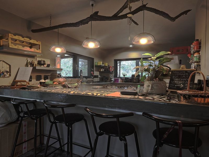 A kitchen featuring a prominent concrete breakfast bar, pendant lighting, and functional workspace with integrated sink and cabinetry.