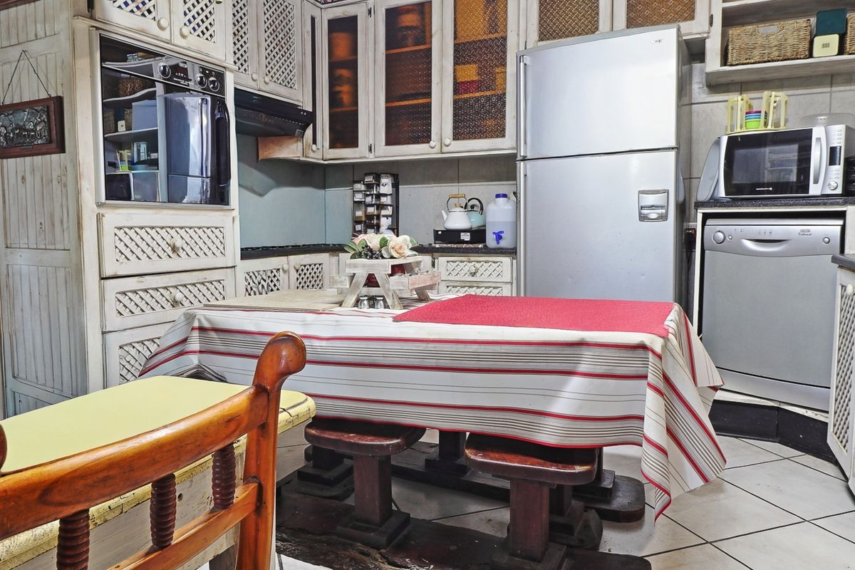 A functional kitchen featuring built-in cabinetry, granite countertops, and integrated appliances, offering a traditional aesthetic with potential for modern updates.