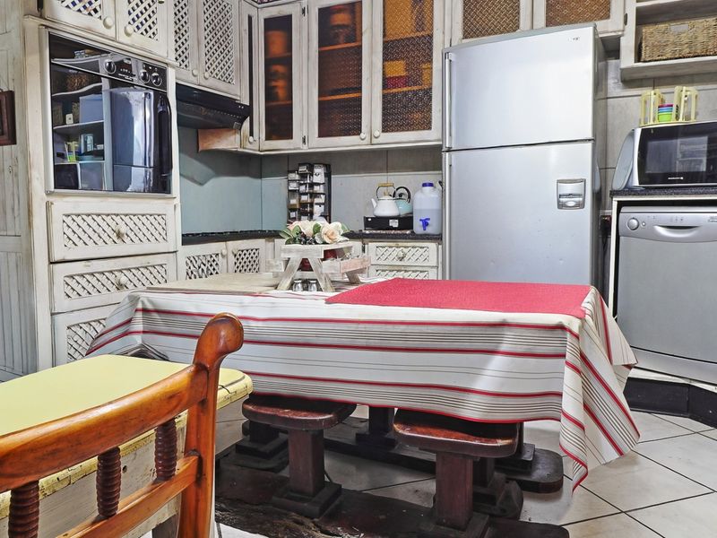 A functional kitchen featuring built-in cabinetry, granite countertops, and integrated appliances, offering a traditional aesthetic with potential for modern updates.