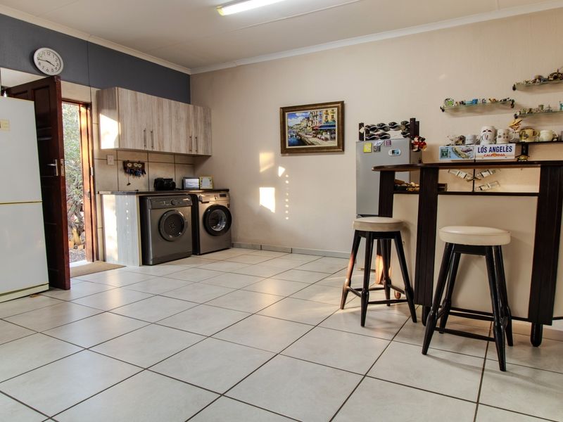 A functional laundry area featuring tiled flooring, built-in cabinetry, and direct access to the exterior.