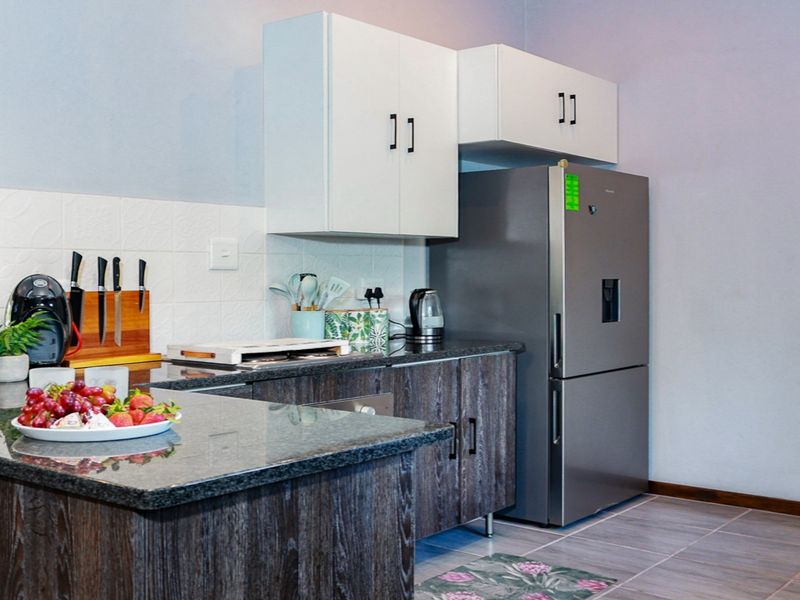 A functional kitchen featuring granite countertops, modern cabinetry, and a tiled backsplash, providing a clean and practical workspace.