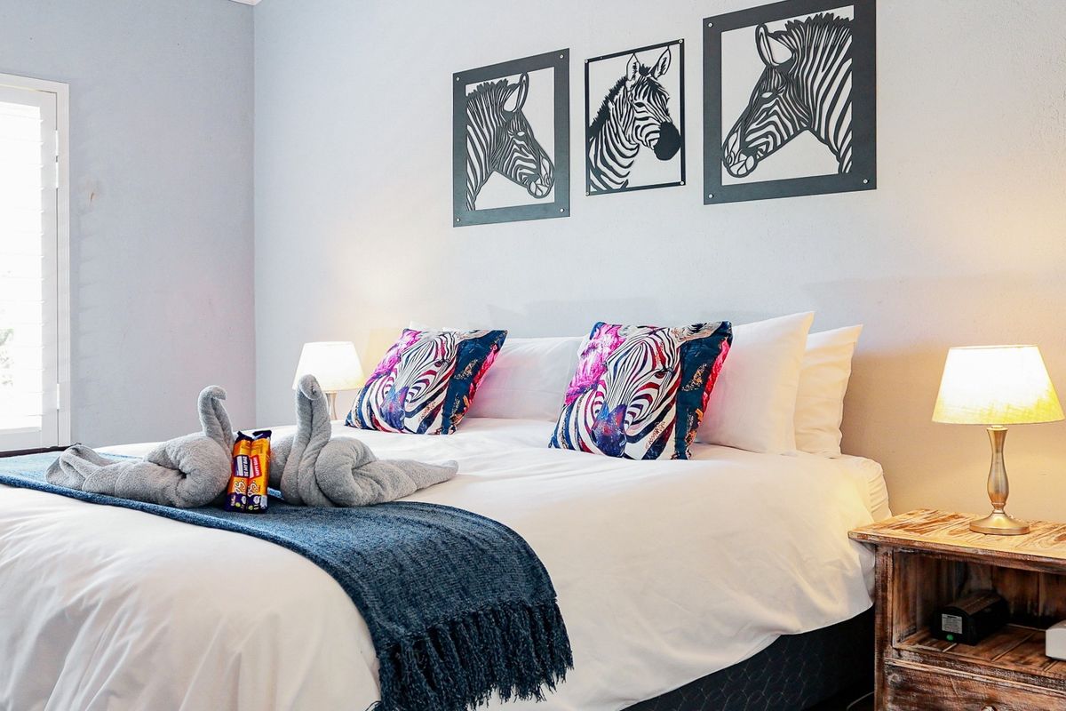 A well-maintained bedroom featuring neutral walls and a shuttered window, providing a comfortable and inviting sleeping space.