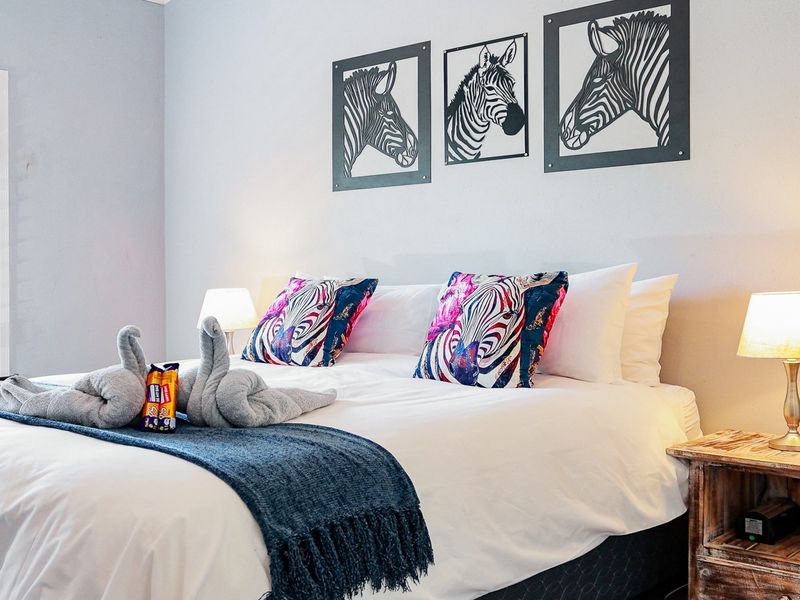 A well-maintained bedroom featuring neutral walls and a shuttered window, providing a comfortable and inviting sleeping space.