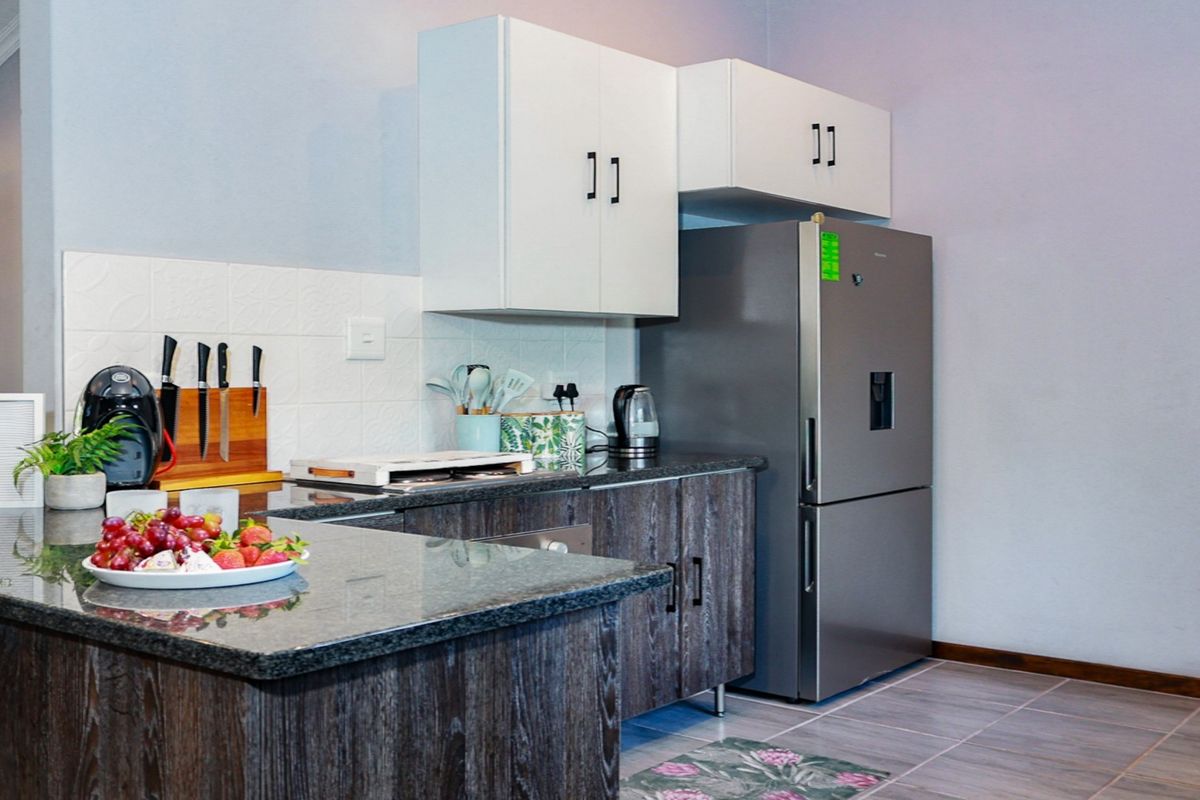A functional kitchen featuring granite countertops, modern cabinetry, and a tiled backsplash, providing a clean and practical workspace.