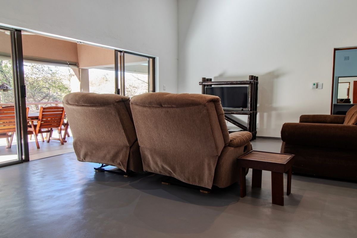 Spacious living area featuring polished concrete floors and large sliding glass doors that provide seamless access to the outdoor patio.