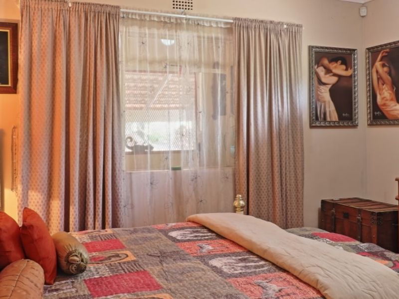 A bedroom featuring a window with curtain tracks, providing natural light and a view to the exterior.
