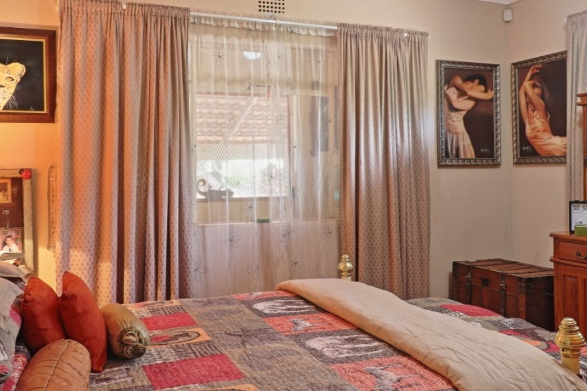 A bedroom featuring a window with curtain tracks, providing natural light and a view to the exterior.