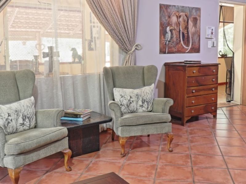 A living area featuring traditional terracotta floor tiles and large windows, providing a warm and classic foundation for interior updates.