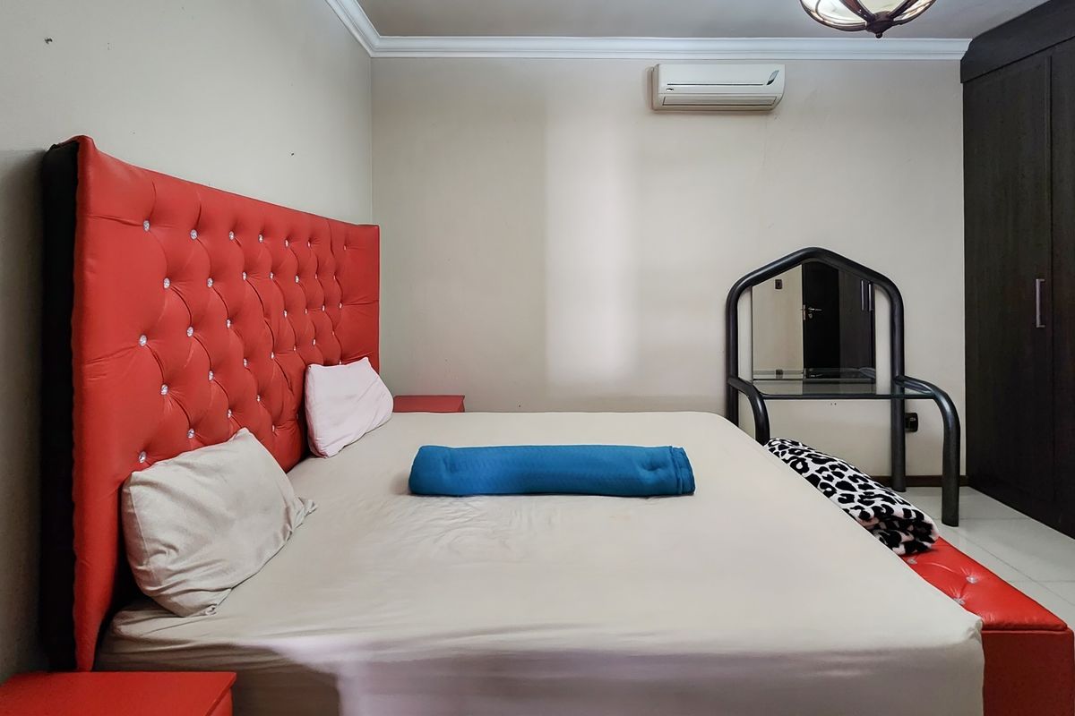 A bedroom featuring tiled flooring, crown molding, a built-in wardrobe, and a wall-mounted split-system air conditioner.