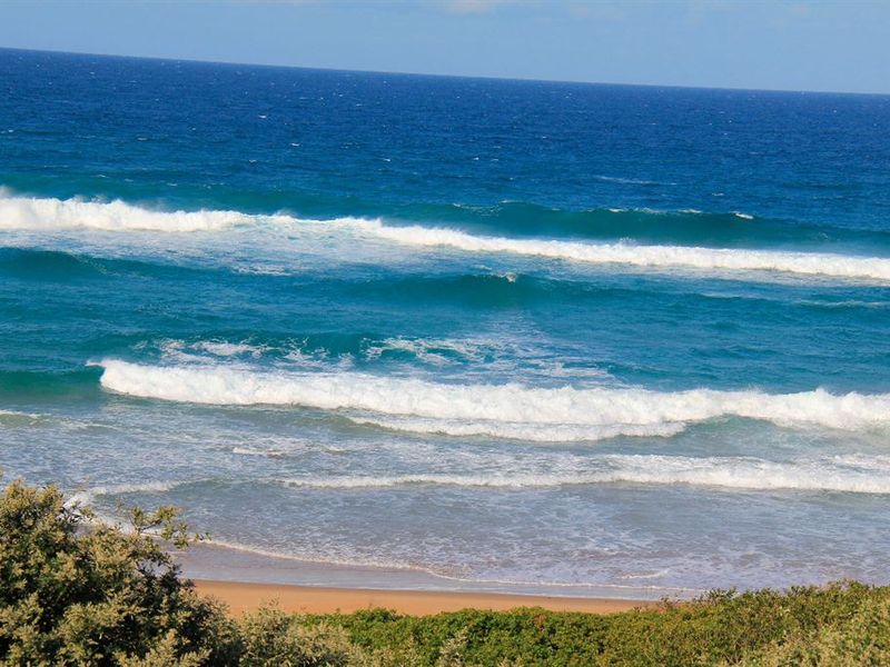 A scenic view of the ocean and sandy beach, showcasing the natural coastal landscape of the property.