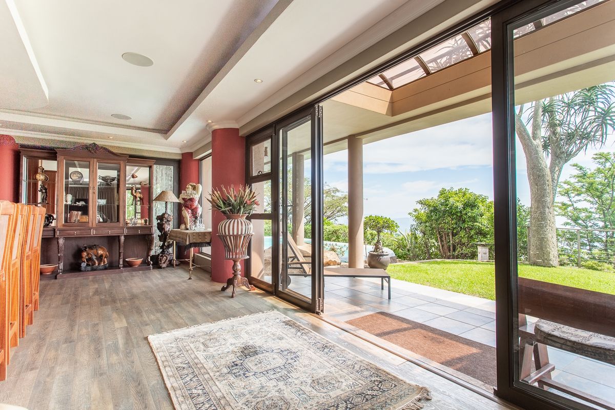 Spacious living area featuring seamless indoor-outdoor flow through large bi-fold glass doors leading to a covered patio and garden.
