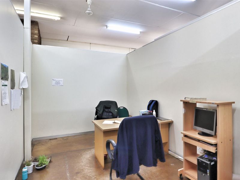 A functional office space featuring partition walls and overhead fluorescent lighting, providing a practical work environment.
