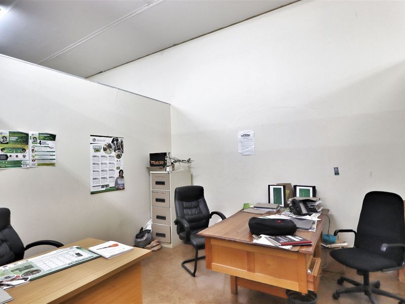 A functional office space featuring partition walls and overhead fluorescent lighting, suitable for a professional work environment.