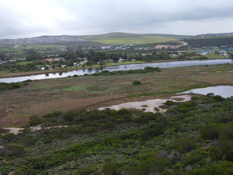 An aerial view of the vacant residential land, showcasing the surrounding natural landscape, wetlands, and river scenery.