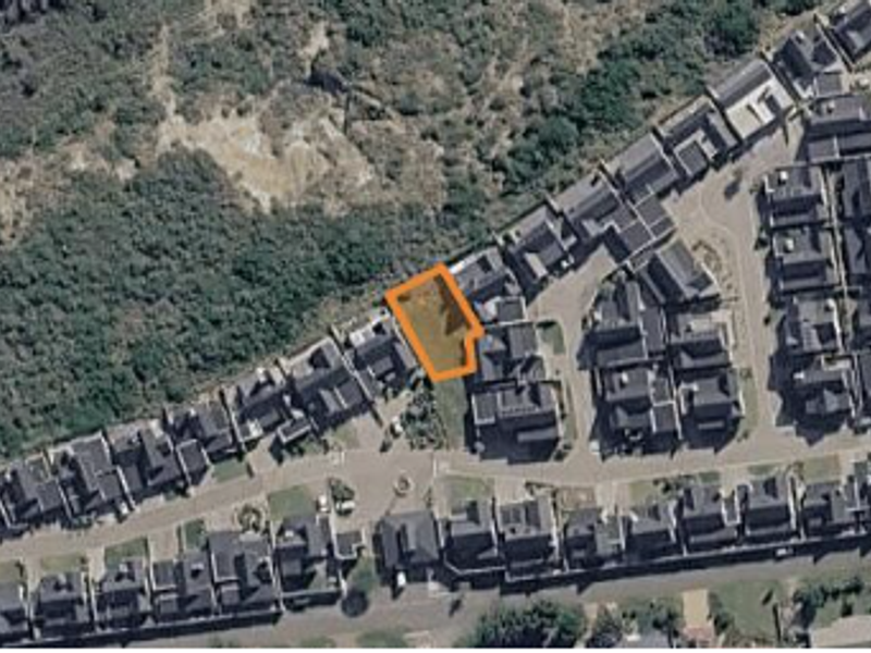 An aerial view of a vacant residential plot situated within a developed estate, highlighting its location and surrounding neighborhood context.
