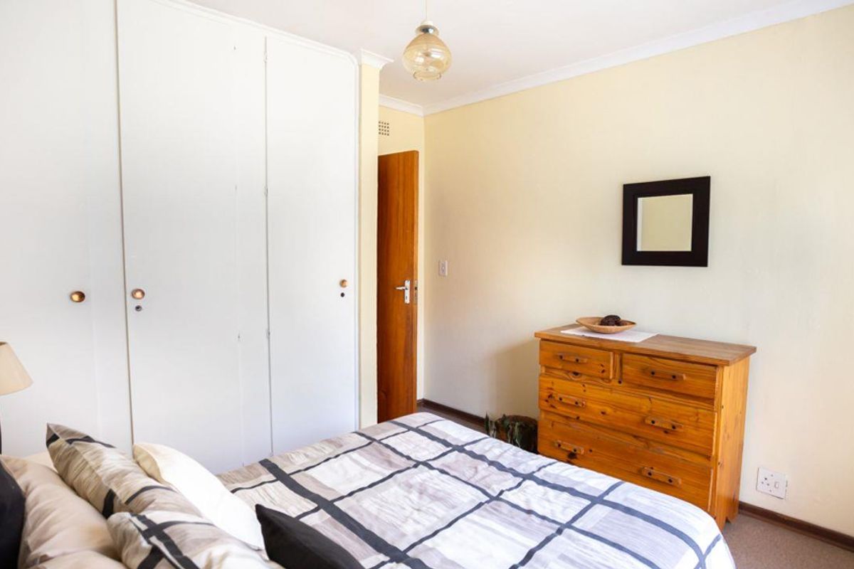 A functional bedroom featuring built-in cupboards and neutral wall finishes, providing a comfortable and practical living space.