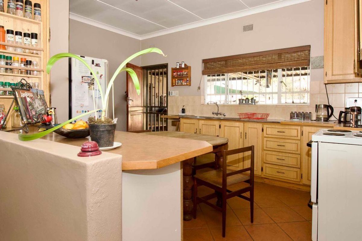 A functional kitchen featuring wooden cabinetry, tiled countertops, and a breakfast bar counter, providing a practical layout for daily meal preparation.