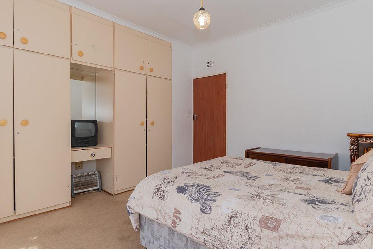 A bedroom featuring built-in floor-to-ceiling cabinetry with integrated vanity and carpeted flooring.