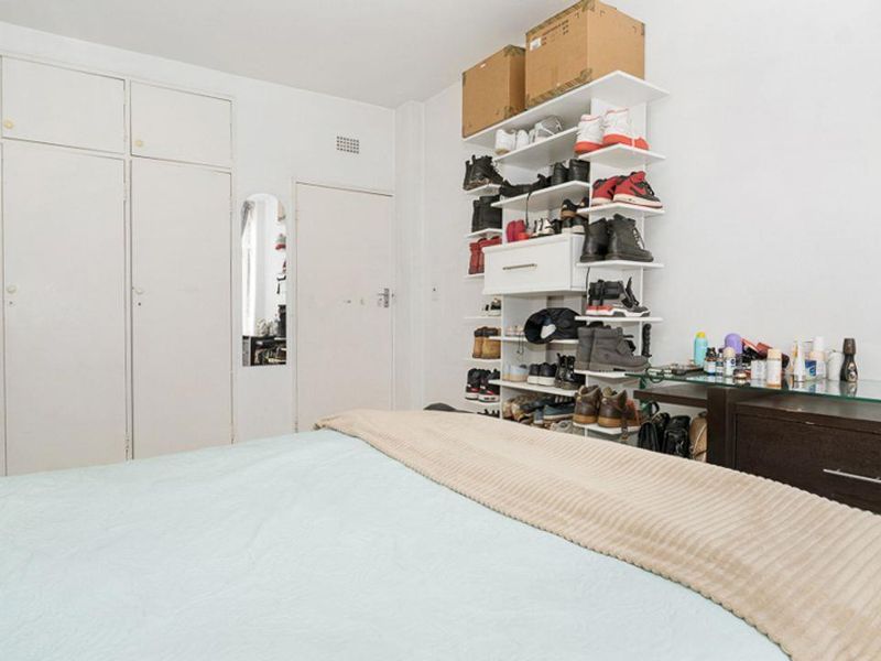 A bedroom featuring built-in cupboards with a neutral interior, offering functional storage space.