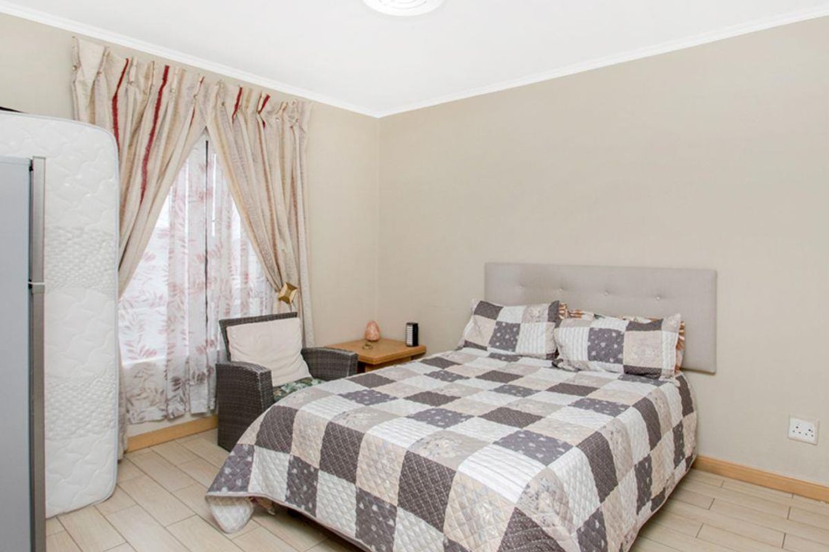 A bedroom featuring tiled flooring and a neutral wall finish, providing a functional and comfortable living space.