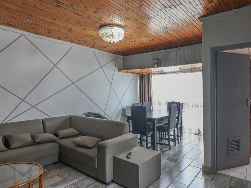 Open plan living and dining area featuring tiled flooring and a timber tongue and groove ceiling.