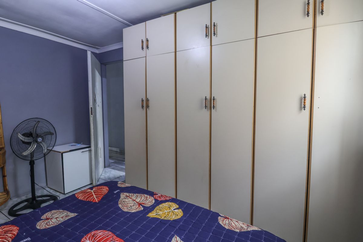 A bedroom featuring extensive floor-to-ceiling built-in cupboards providing ample storage space.