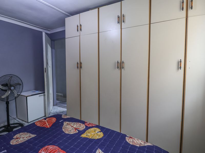A bedroom featuring extensive floor-to-ceiling built-in cupboards providing ample storage space.