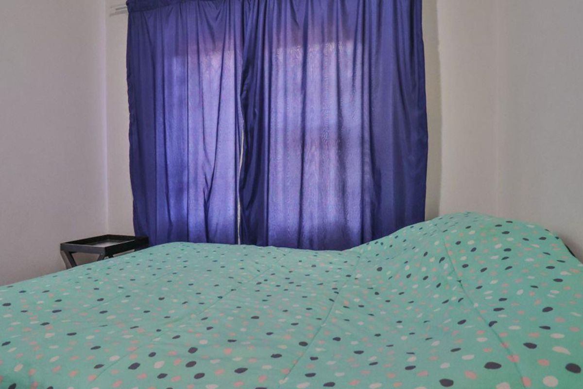 A bedroom featuring a window with curtains.