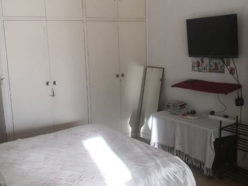 A bedroom featuring floor-to-ceiling built-in cupboards providing ample storage space.