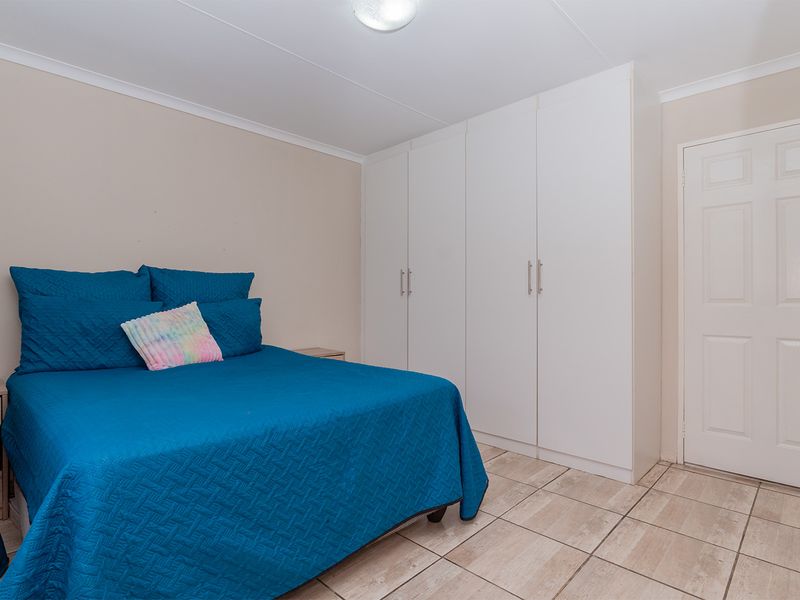 A bedroom featuring built-in white cabinetry and tiled flooring.