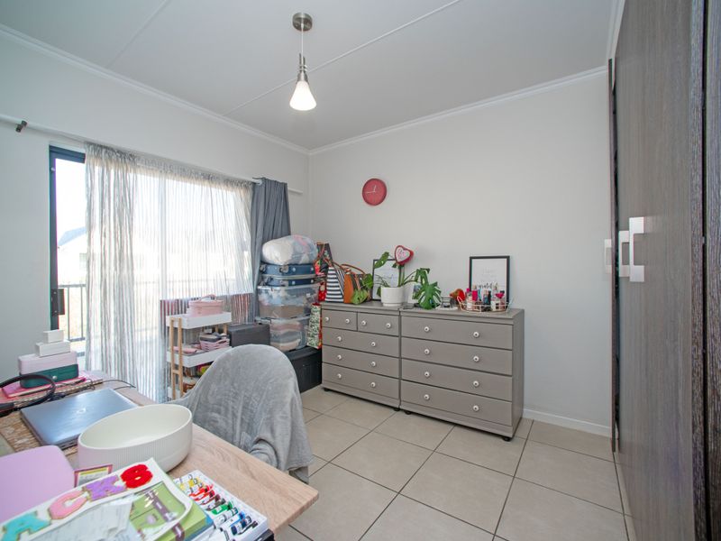 A bedroom featuring tiled flooring, a built-in wardrobe, and a sliding glass door providing access to an outdoor area.